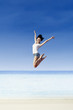 Photo: Asian girl jump at white sand beach Asian girl jump at white sand beach