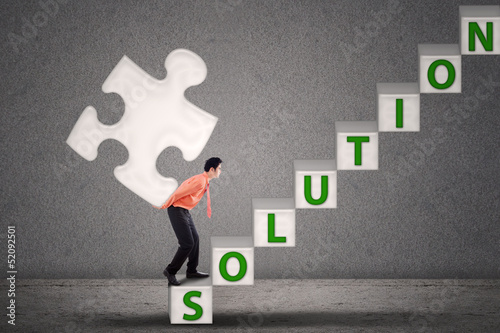 Photo: Businessman bring puzzle of solution Businessman bring puzzle of solution