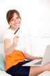Foto: woman with card in hand and laptop woman with card in hand and laptop