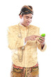 man with traditional java suit using mobile phone