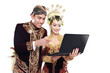 happy traditional java wedding couple with laptop