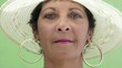 Happy mature hispanic woman with hat looking at camera, smiling