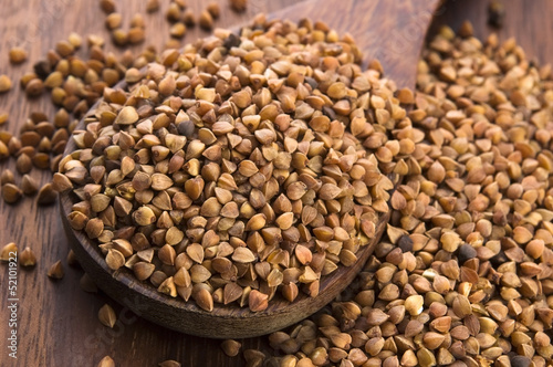 Photo: Buckwheat seeds on wooden spoon in closeup Buckwheat seeds on wooden spoon in closeup