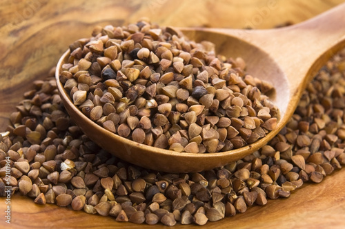 Photo: Buckwheat seeds on wooden spoon in closeup Buckwheat seeds on wooden spoon in closeup