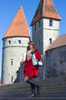 Photo: young woman standing on stairs in old town young woman standing on stairs in old town
