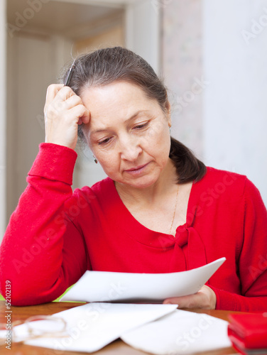 Photo: Sadness mature woman with bills Sadness mature woman with bills