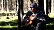 Man playing guitar in forest