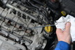 Foto : Auto mechanic checking engine oil level. Auto mechanic checking engine oil level.