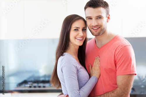 Photo: Couple embracing in kitchen Couple embracing in kitchen