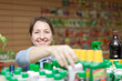 Photo: female mature gardener chooses fertilizer female mature gardener chooses fertilizer
