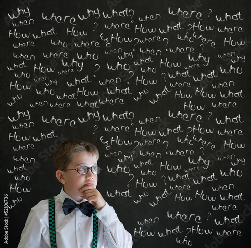 Photo: Boy businessman with chalk questions blackboard Boy businessman with chalk questions blackboard