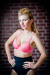 girl in swimsuit posing provocatively in front of a brick wall