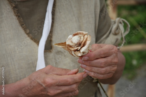 Photo: hands of an elderly woman while creating a wooden flower hands of an elderly woman while creating a wooden flower