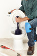 Photo: The worker with a plunger The worker with a plunger