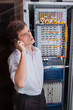Network engineer in server room talking on the mobile phone