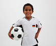 Dunkelhäutiger Junge mit Ball und Trikot im Deutschland-Look