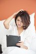 young beautiful women looking a tablet on bed, acting Confuse