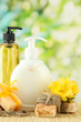 Liquid and hand-made soaps on wooden table, on green background