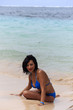 junge Frau in Bikini sitz am Strand