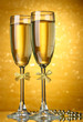 Two glasses of champagne on bright background with lights