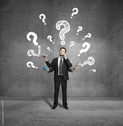 Photo: businessman with four hands and question marks businessman with four hands and question marks