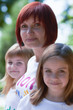 Young mother and her cute daughters outdoors