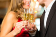 Man and woman tasting Champagne in restaurant