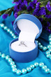 Flowers  and engagement ring on blue cloth