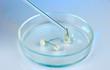 Chemical research in Petri dish on light blue background