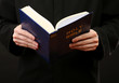 Priest reading from the holy bible, close up