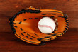 Baseball glove and ball on wooden background