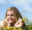 Young woman relaxing between dandelions