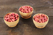 Peanuts in bowls on wooden background