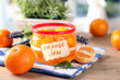 Orange jam with zest and tangerines, on wooden table