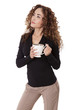 Woman with thick hair stands holding a coffee cup.