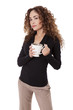 Woman in tan pants and a black shirt holds a coffee cup.