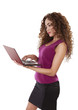 Latin woman works on her computer while standing.