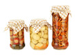 Delicious marinated mushrooms in glass jars, isolated on white