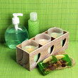 Candles in wooden candlestick, cosmetics bottles and soap,