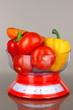 Fresh vegetables in scales on gray background