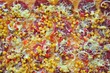 Foto: View of pizza with corn and salami as background View of pizza with corn and salami as background