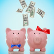 Hundred Dollar bills falling in a piggy bank couple