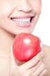 Foto: young woman eating red apple with health teeth young woman eating red apple with health teeth