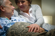 Elderly couple holding hands lying in bed