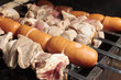 Close-up of pork meat and sausages on fire