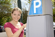Photo: Junge Frau bedient Parkscheinautomaten Junge Frau bedient Parkscheinautomaten