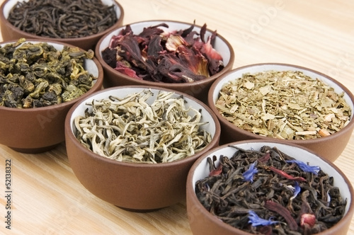 Photo: Assortment of dry tea in ceramic bowls Assortment of dry tea in ceramic bowls