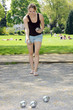Photo: Junge Frau spielt Boule im Park Junge Frau spielt Boule im Park