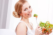 Photo: lachende junge frau isst gesunden salat lachende junge frau isst gesunden salat