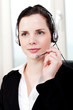 Junge brünette Frau arbeitet in einem callcenter mit headset